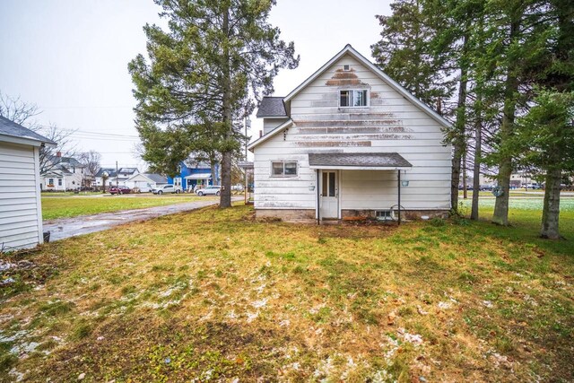 rear view of property featuring a yard