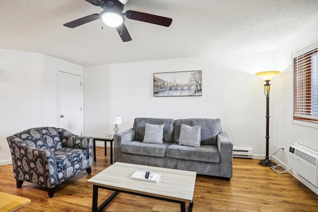 living room with a textured ceiling, a baseboard radiator, wood-type flooring, and ceiling fan