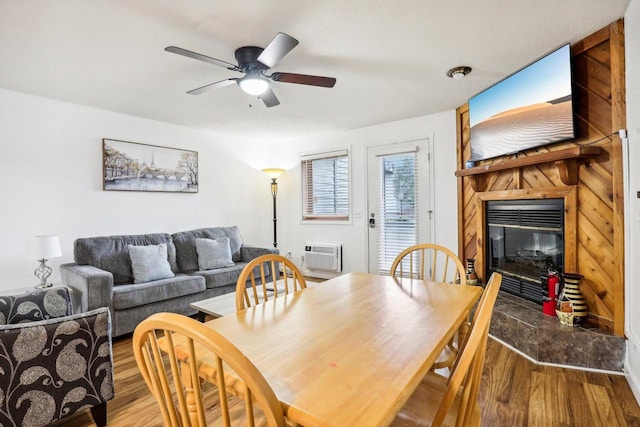 dining area with hardwood / wood-style flooring, ceiling fan, and an AC wall unit