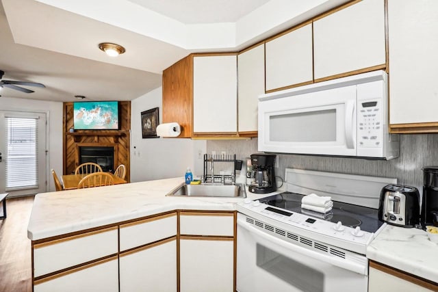 kitchen featuring white cabinets, white appliances, and kitchen peninsula