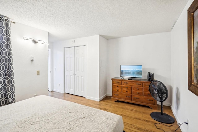 bedroom with wood-type flooring, a textured ceiling, and a closet