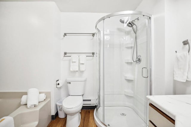 bathroom with toilet, a baseboard heating unit, wood-type flooring, and a shower with shower door