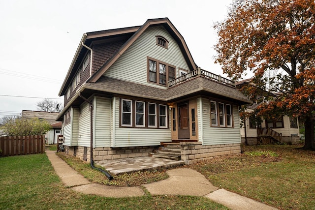 view of front of property with a front lawn and a balcony