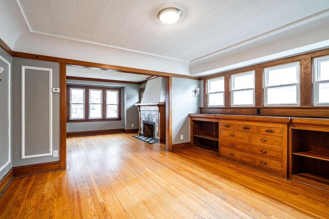 unfurnished living room with light hardwood / wood-style flooring and crown molding