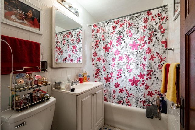 full bathroom with shower / bath combo, toilet, tile walls, vanity, and backsplash