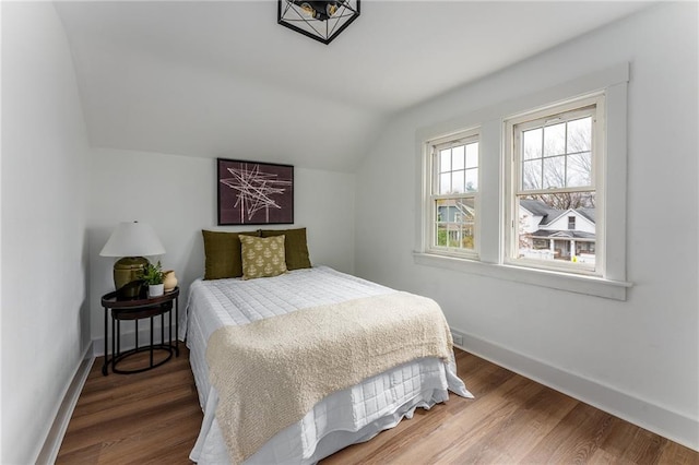 bedroom featuring hardwood / wood-style floors and lofted ceiling