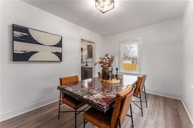 dining space with hardwood / wood-style floors and sink