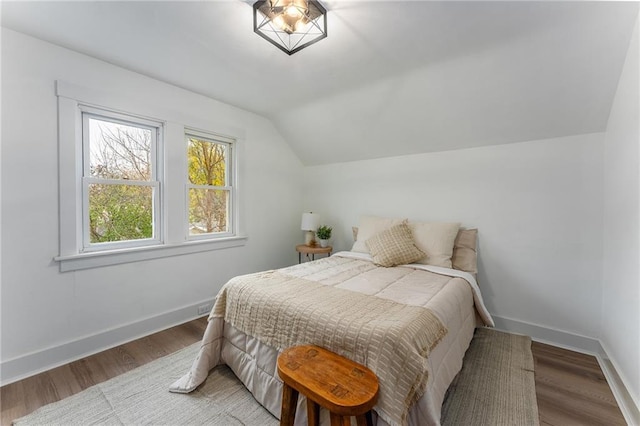 bedroom featuring wood-type flooring and vaulted ceiling