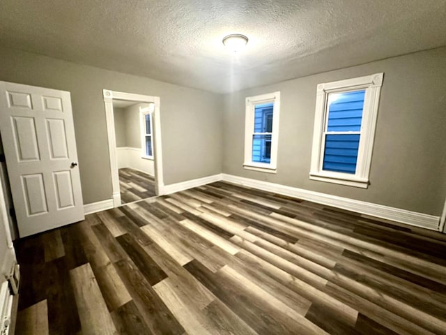 unfurnished bedroom with dark hardwood / wood-style flooring and a textured ceiling