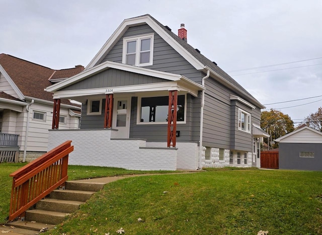 bungalow with covered porch and a front yard