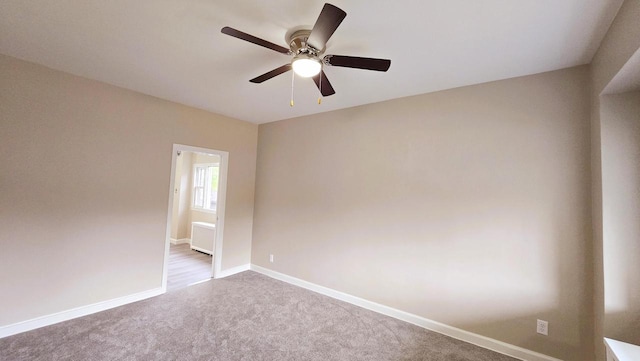 carpeted empty room featuring ceiling fan