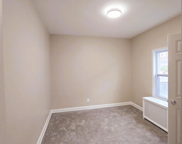 empty room with radiator heating unit and carpet