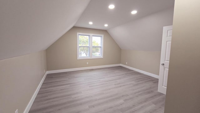 additional living space featuring lofted ceiling and light wood-type flooring