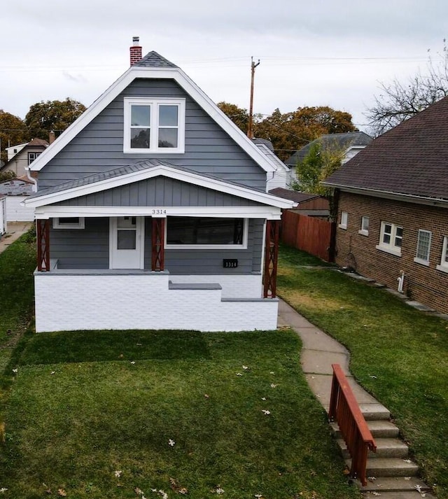 back of property with a porch and a yard