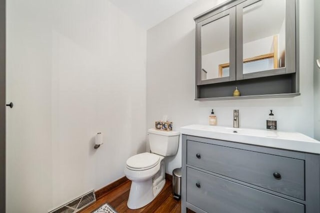 bathroom featuring vanity, hardwood / wood-style flooring, and toilet