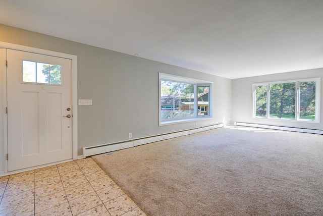 entryway with a baseboard heating unit, light carpet, and plenty of natural light