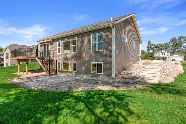 rear view of property with a patio area, a yard, and a wooden deck