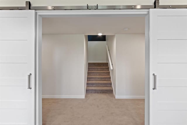 stairs with carpet and a barn door