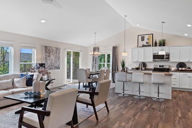 living room featuring dark wood-type flooring, an inviting chandelier, and vaulted ceiling