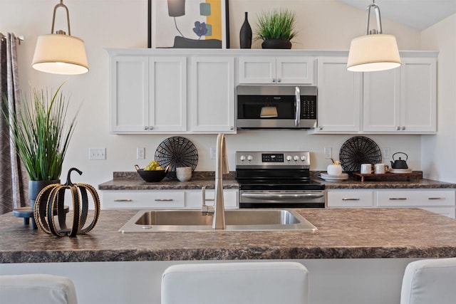 kitchen featuring stainless steel appliances, a kitchen breakfast bar, hanging light fixtures, and white cabinets