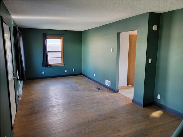 empty room featuring hardwood / wood-style floors and a textured ceiling