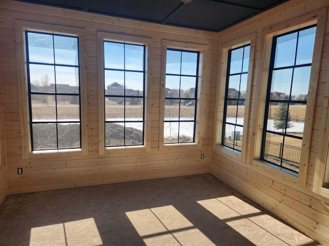 unfurnished sunroom with plenty of natural light and a water view