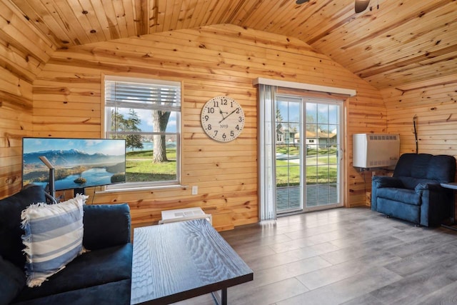 living room featuring heating unit, hardwood / wood-style floors, wood ceiling, wooden walls, and vaulted ceiling