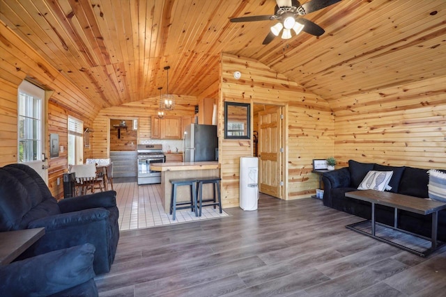 living room featuring wood walls, hardwood / wood-style floors, wooden ceiling, and vaulted ceiling