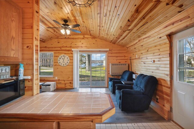 living room featuring plenty of natural light, wooden walls, wood ceiling, and vaulted ceiling