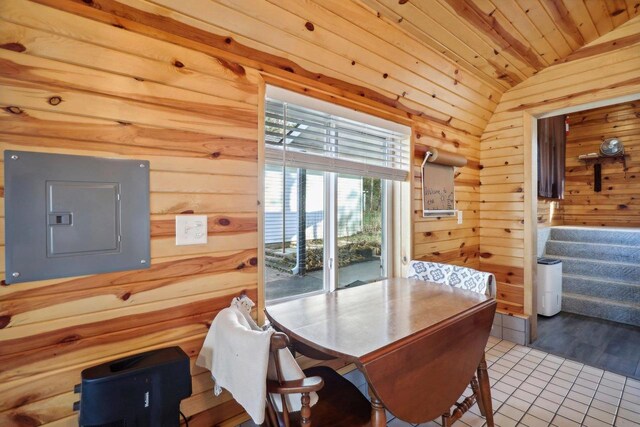 dining room featuring electric panel, vaulted ceiling, hardwood / wood-style flooring, wooden walls, and wooden ceiling