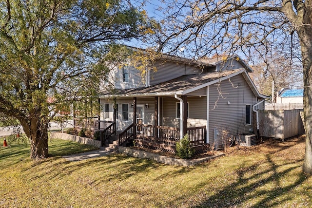 view of front of property with a front lawn, a storage unit, central AC, and covered porch