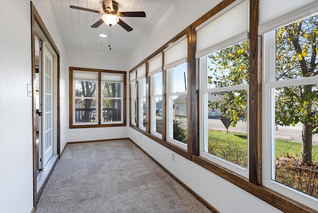 unfurnished sunroom with ceiling fan, wood ceiling, and a healthy amount of sunlight