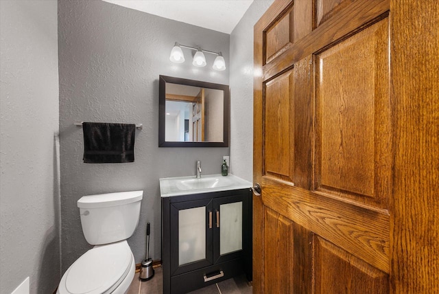 bathroom with tile patterned flooring, vanity, and toilet