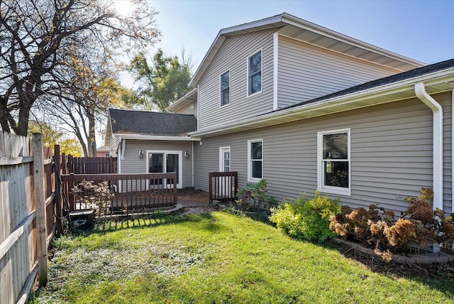 rear view of property featuring a lawn