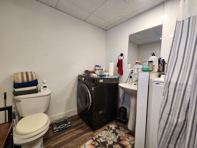 bathroom with toilet, washer / clothes dryer, a drop ceiling, and wood-type flooring