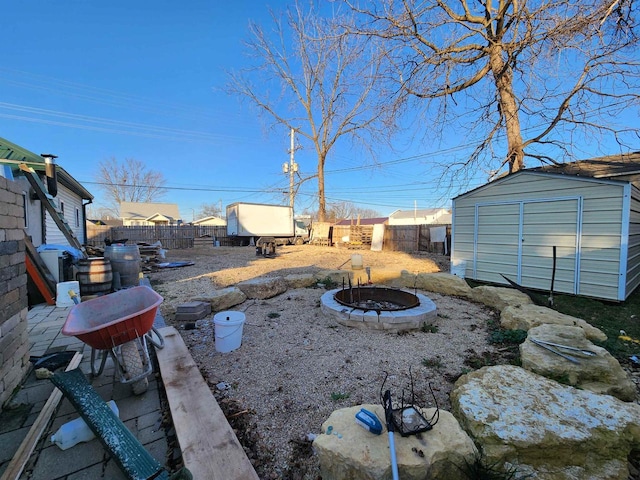 view of yard featuring a patio, an outdoor fire pit, and a storage unit