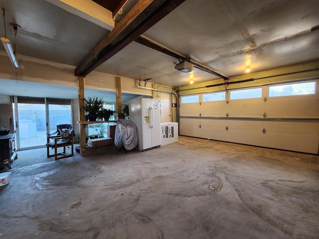 garage with a garage door opener and white refrigerator with ice dispenser