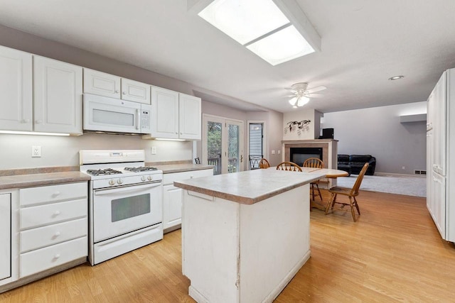 kitchen with white cabinetry, white appliances, ceiling fan, and light wood-type flooring