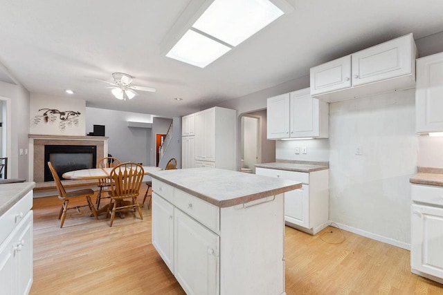 kitchen featuring white cabinets, light hardwood / wood-style floors, and a center island