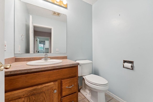 bathroom featuring vanity, tile patterned floors, and toilet