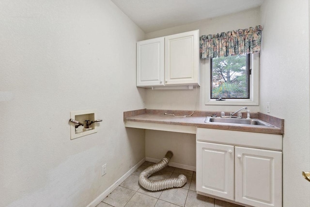 laundry area with washer hookup, cabinets, sink, and light tile patterned flooring