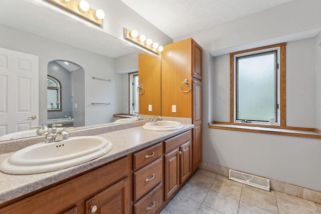 bathroom featuring vanity, a textured ceiling, and tile patterned flooring