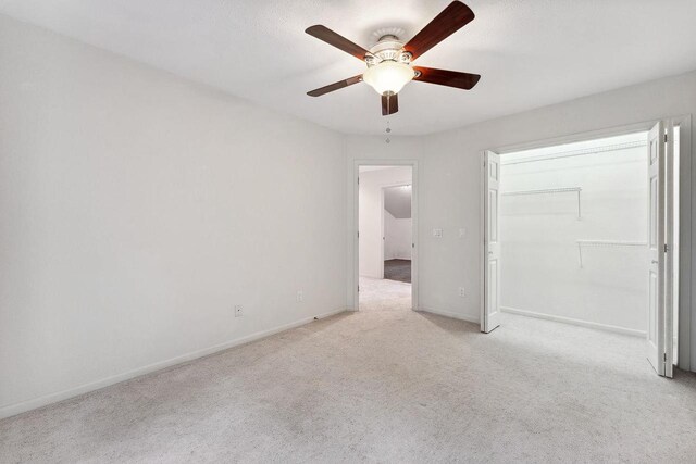 unfurnished bedroom with a closet, light carpet, and ceiling fan