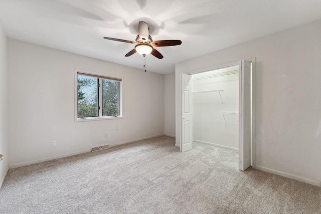 unfurnished bedroom featuring a closet, light colored carpet, and ceiling fan