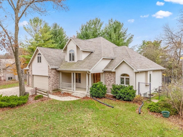 view of front of house featuring a porch, a front lawn, and a garage