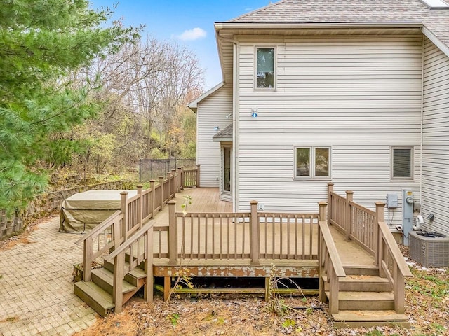 back of property with central AC unit and a wooden deck