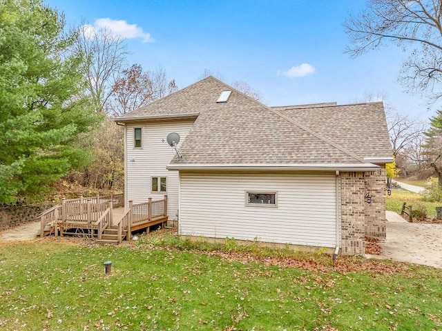 rear view of property featuring a lawn and a wooden deck