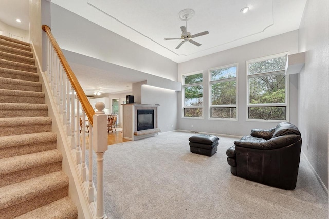 carpeted living room with ceiling fan