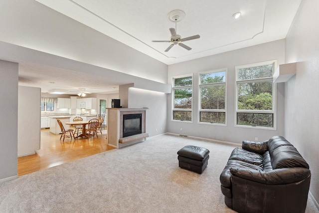 living room with ceiling fan and light hardwood / wood-style floors