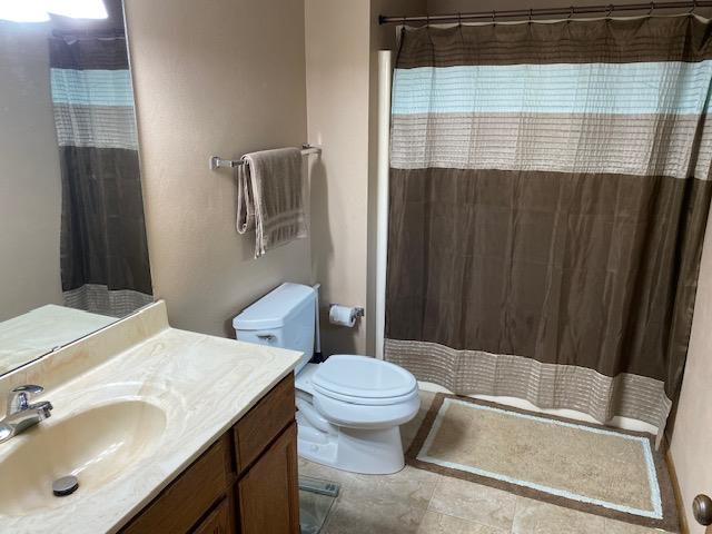 bathroom featuring walk in shower, vanity, and toilet